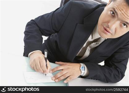 Portrait of a businessman writing a check
