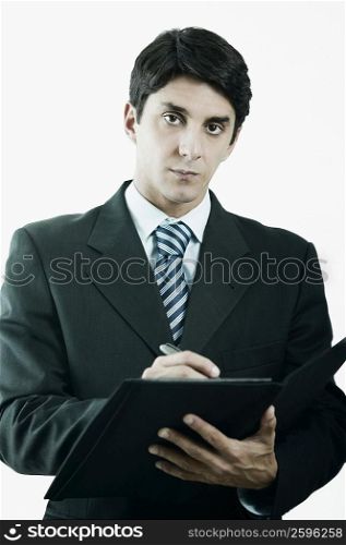 Portrait of a businessman writing on a file