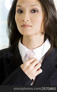 Portrait of a businesswoman adjusting her tie