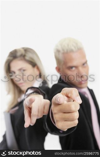 Portrait of a businesswoman and a businessman standing back to back and pointing