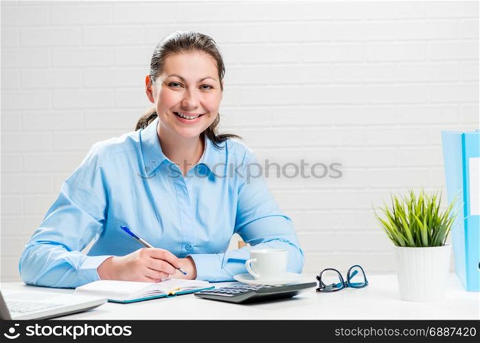 Portrait of a businesswoman at a white table in an office at work