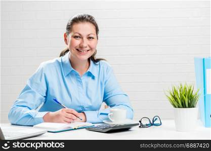 Portrait of a businesswoman at a white table in an office at work