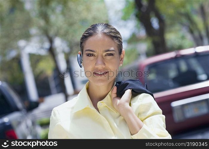 Portrait of a businesswoman carrying a coat on her shoulder and smiling