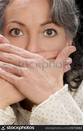 Portrait of a businesswoman covering mouth with hands