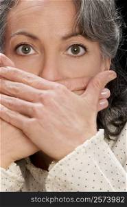 Portrait of a businesswoman covering mouth with hands