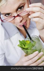 Portrait of a businesswoman drinking a glass of mint julep