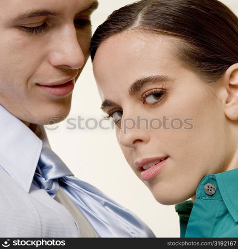 Portrait of a businesswoman holding a businessman by his tie