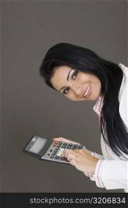 Portrait of a businesswoman holding a calculator and smiling
