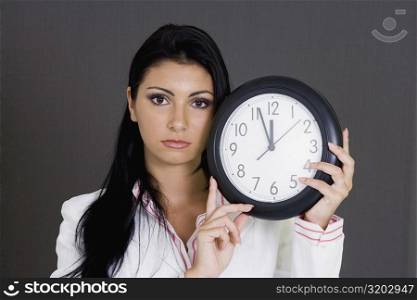 Portrait of a businesswoman holding a clock