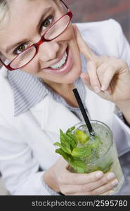 Portrait of a businesswoman holding a glass of mint julep and smiling