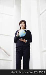 Portrait of a businesswoman holding a globe
