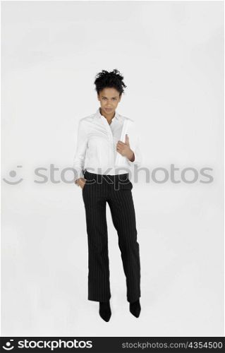 Portrait of a businesswoman holding a laptop with her hand in her pocket