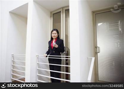 Portrait of a businesswoman holding a mobile phone and smiling