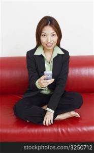 Portrait of a businesswoman holding a mobile phone and smiling