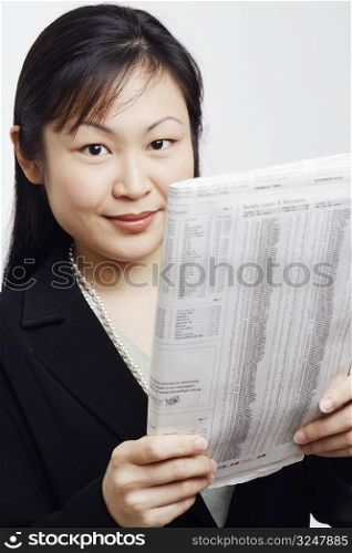 Portrait of a businesswoman holding a newspaper and smiling