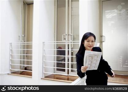 Portrait of a businesswoman holding a newspaper and smiling