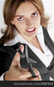 Portrait of a businesswoman holding a pair of scissors and clenching her teeth