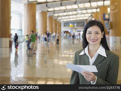 Portrait of a businesswoman holding an airplane ticket