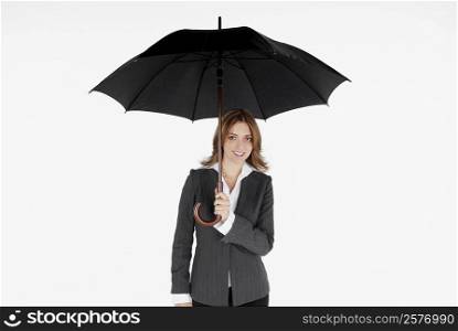 Portrait of a businesswoman holding an umbrella and smiling