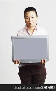 Portrait of a businesswoman holding the model of a computer monitor with progress reports