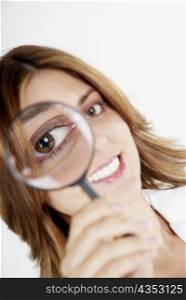 Portrait of a businesswoman looking through a magnifying glass