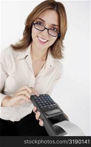 Portrait of a businesswoman operating a credit card reader and smiling