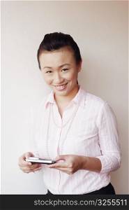 Portrait of a businesswoman operating a mobile phone and smiling