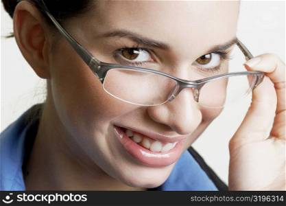 Portrait of a businesswoman peeking over her eyeglasses and smiling