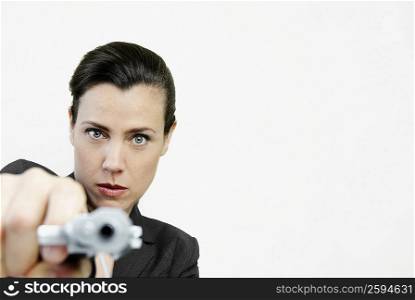 Portrait of a businesswoman pointing a gun