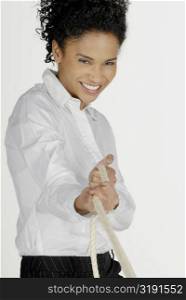 Portrait of a businesswoman pulling a rope and smiling