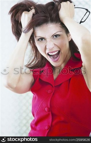 Portrait of a businesswoman shouting with her hands in her hair
