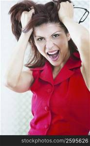 Portrait of a businesswoman shouting with her hands in her hair