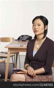 Portrait of a businesswoman sitting and holding a personal data assistant