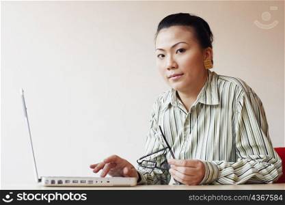 Portrait of a businesswoman sitting in an office and using a laptop