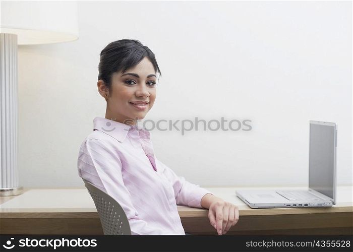 Portrait of a businesswoman sitting in front of a laptop