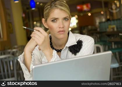 Portrait of a businesswoman sitting in front of a laptop in a restaurant