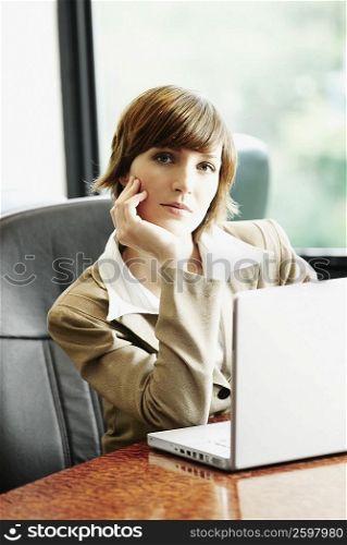 Portrait of a businesswoman sitting in front of a laptop in an office