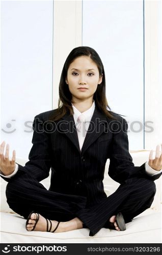 Portrait of a businesswoman sitting in the lotus position