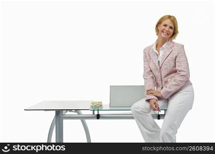 Portrait of a businesswoman sitting on a table and smiling