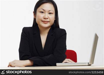 Portrait of a businesswoman sitting with a laptop