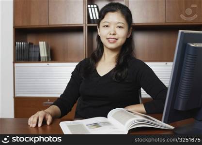 Portrait of a businesswoman sitting with a magazine on the table