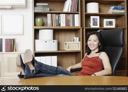 Portrait of a businesswoman sitting with her legs on the table