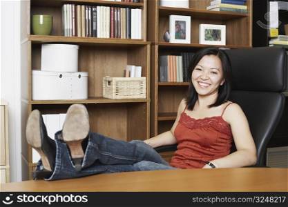 Portrait of a businesswoman sitting with her legs on the table
