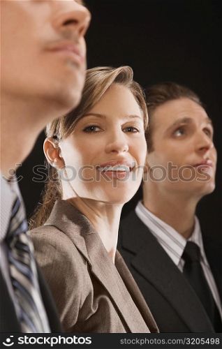 Portrait of a businesswoman smiling between two businessmen