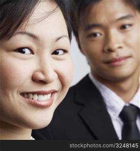 Portrait of a businesswoman smiling with a businessman beside her