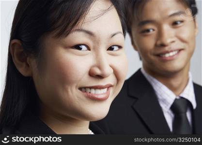 Portrait of a businesswoman smiling with a businessman beside her