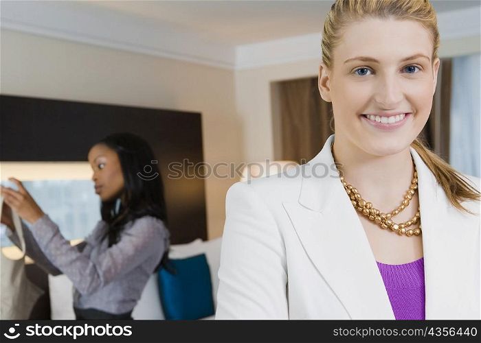 Portrait of a businesswoman smiling with another businesswoman standing in the background