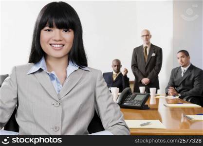 Portrait of a businesswoman smiling with her colleagues in the background