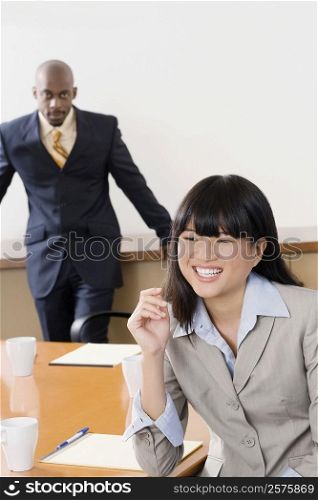 Portrait of a businesswoman smiling with other businessman standing in the background