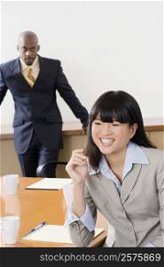 Portrait of a businesswoman smiling with other businessman standing in the background